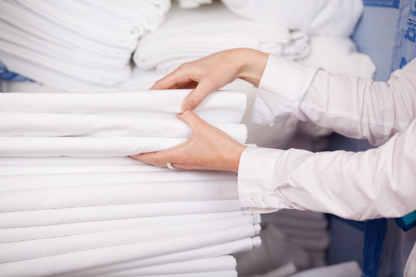 Closeup of white bedsheets stacked in store room